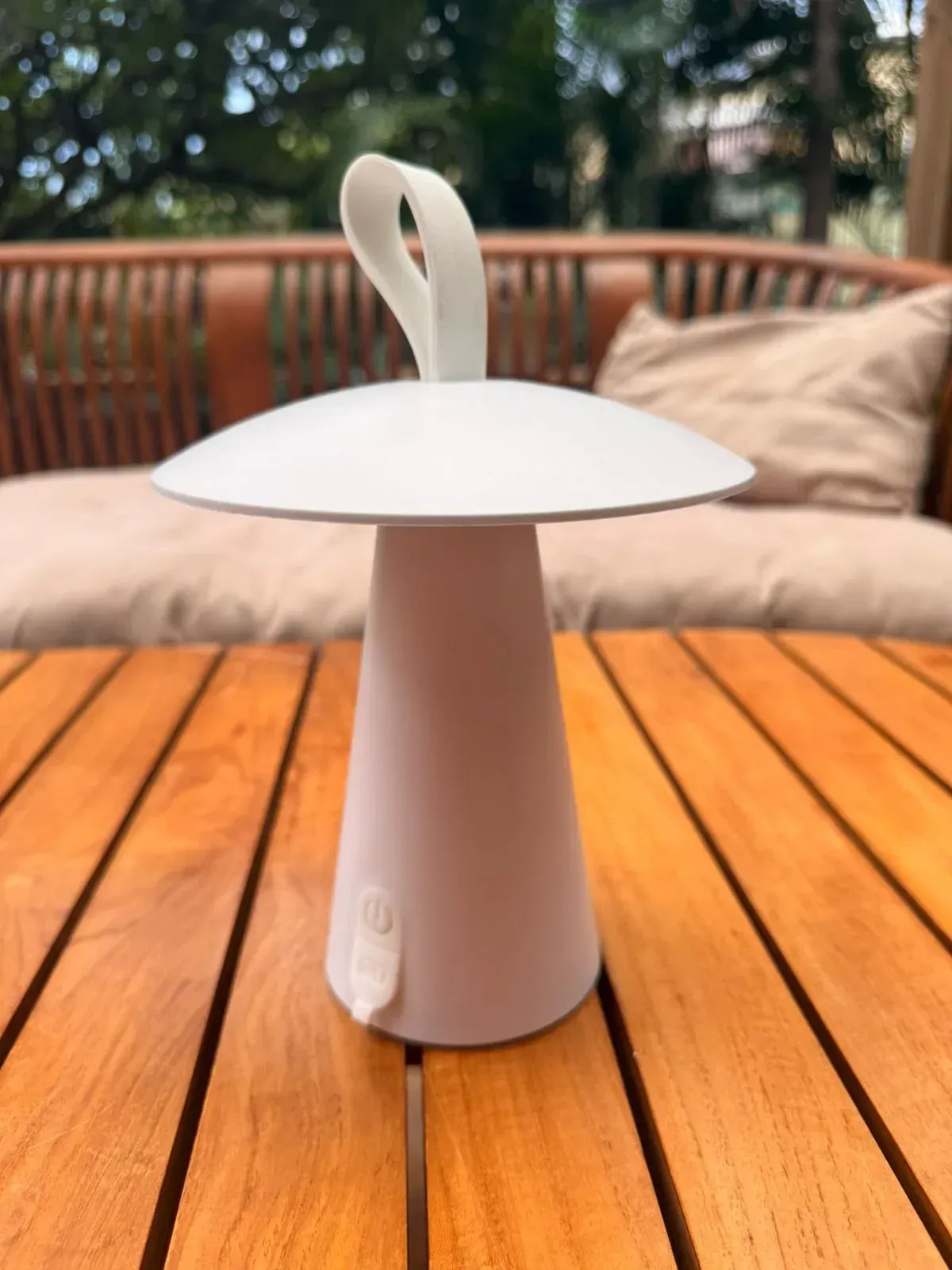 Lampe LED champignon blanche posée sur une table en bois en extérieur, lumière d'ambiance pour un dîner de mariage
