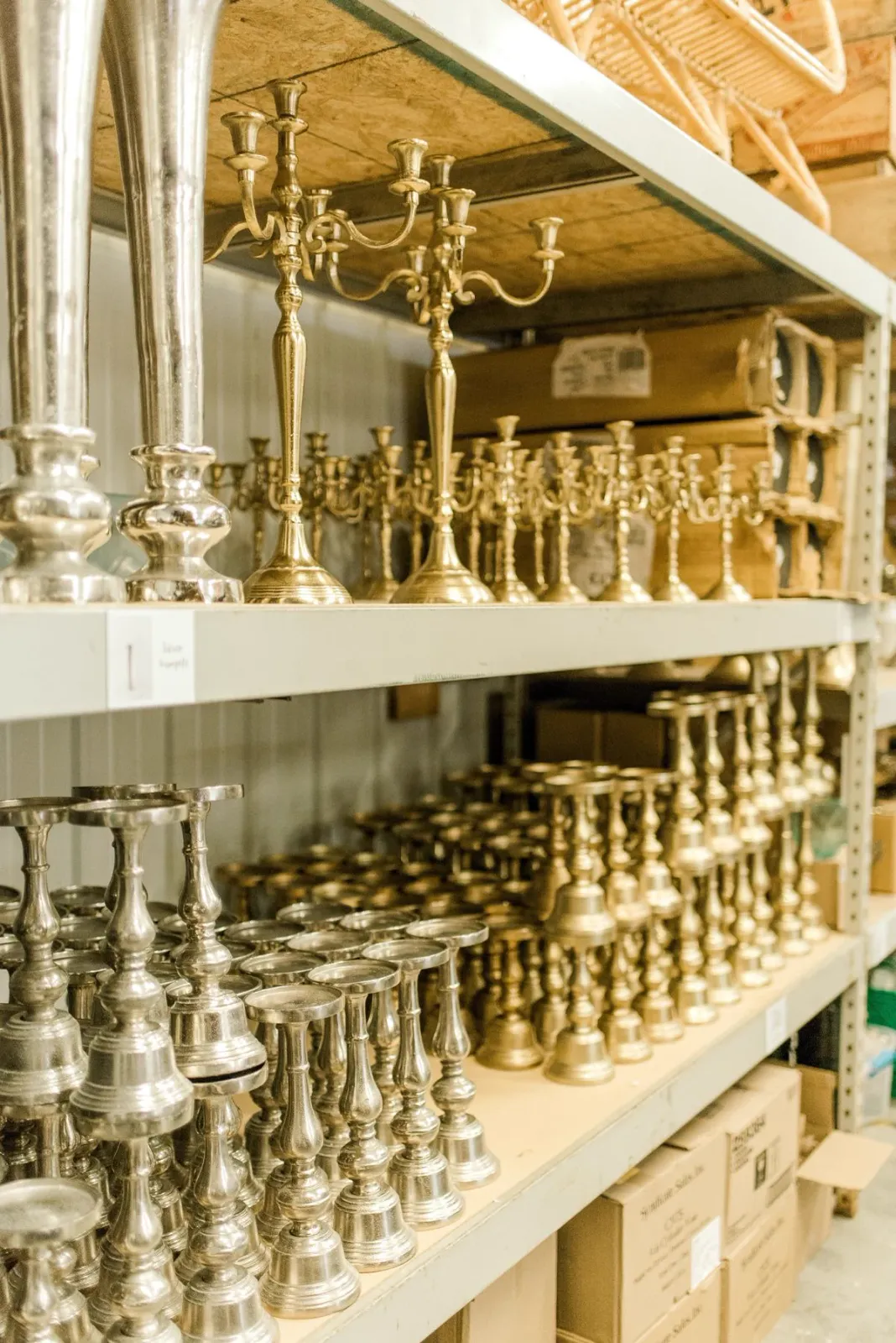 Chandeliers et pièces de décoration dorés rangés sur des étagères métalliques
