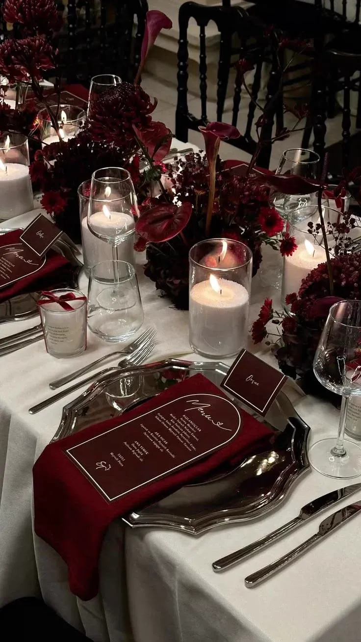 Table de fête bordeaux et argent avec chemin de table, assiettes et bougies