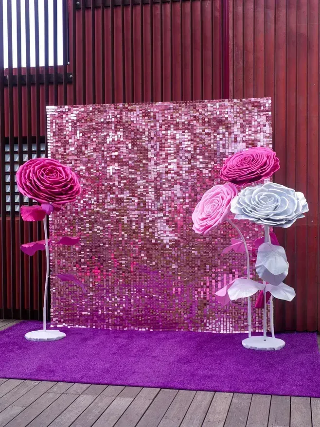 Photocall à sequins rose avec grandes fleurs, espace photo pour un mariage